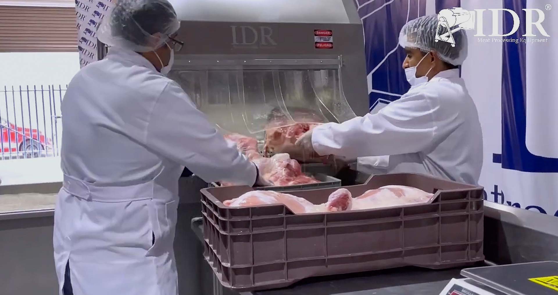 foto de trabajadores manipulando carne en máquina de inyección